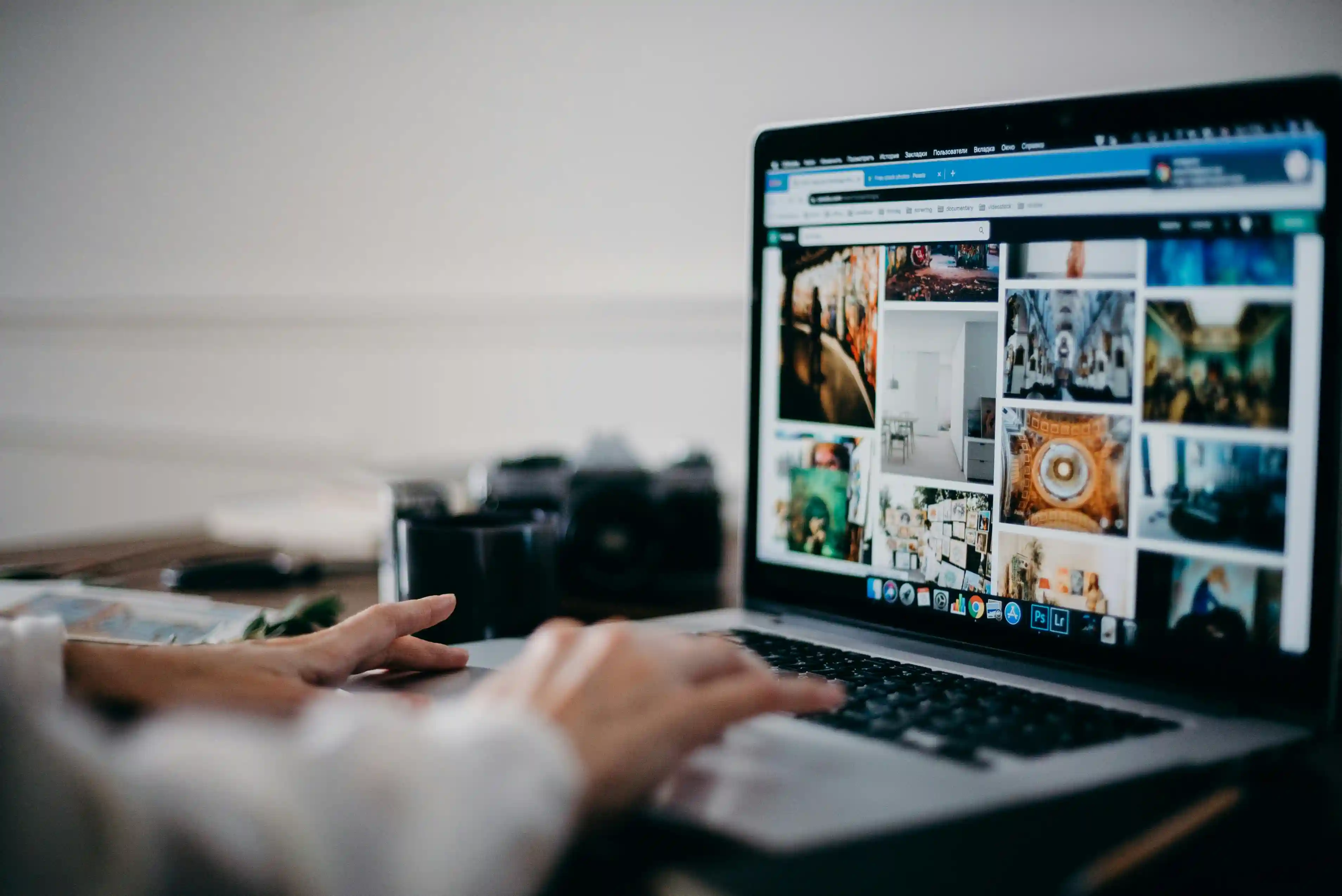 A human hand clicking a laptop keyboard and uploading images on internet